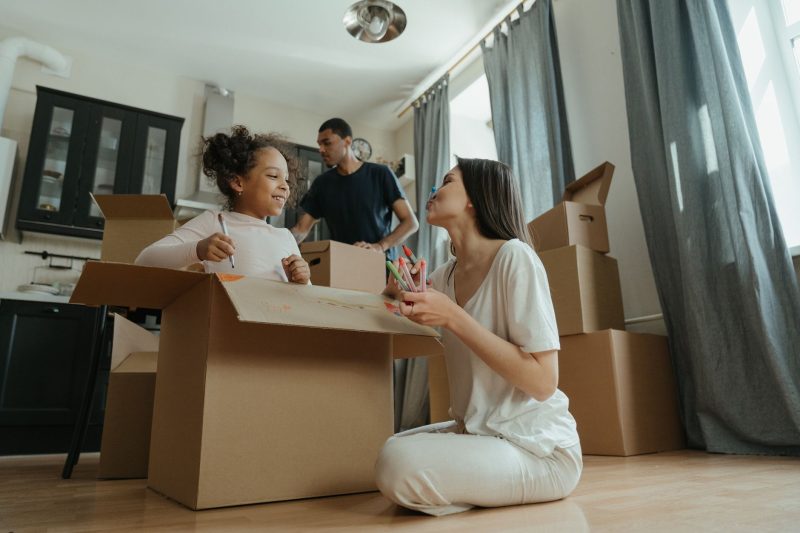 Home 12 A joyful family unpacking boxes while moving into their new 1793120483